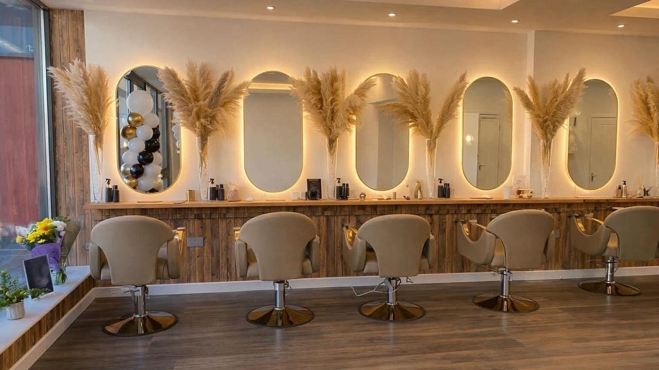 Deeluxe Shyne salon, with oval mirrors, wood, and pampas